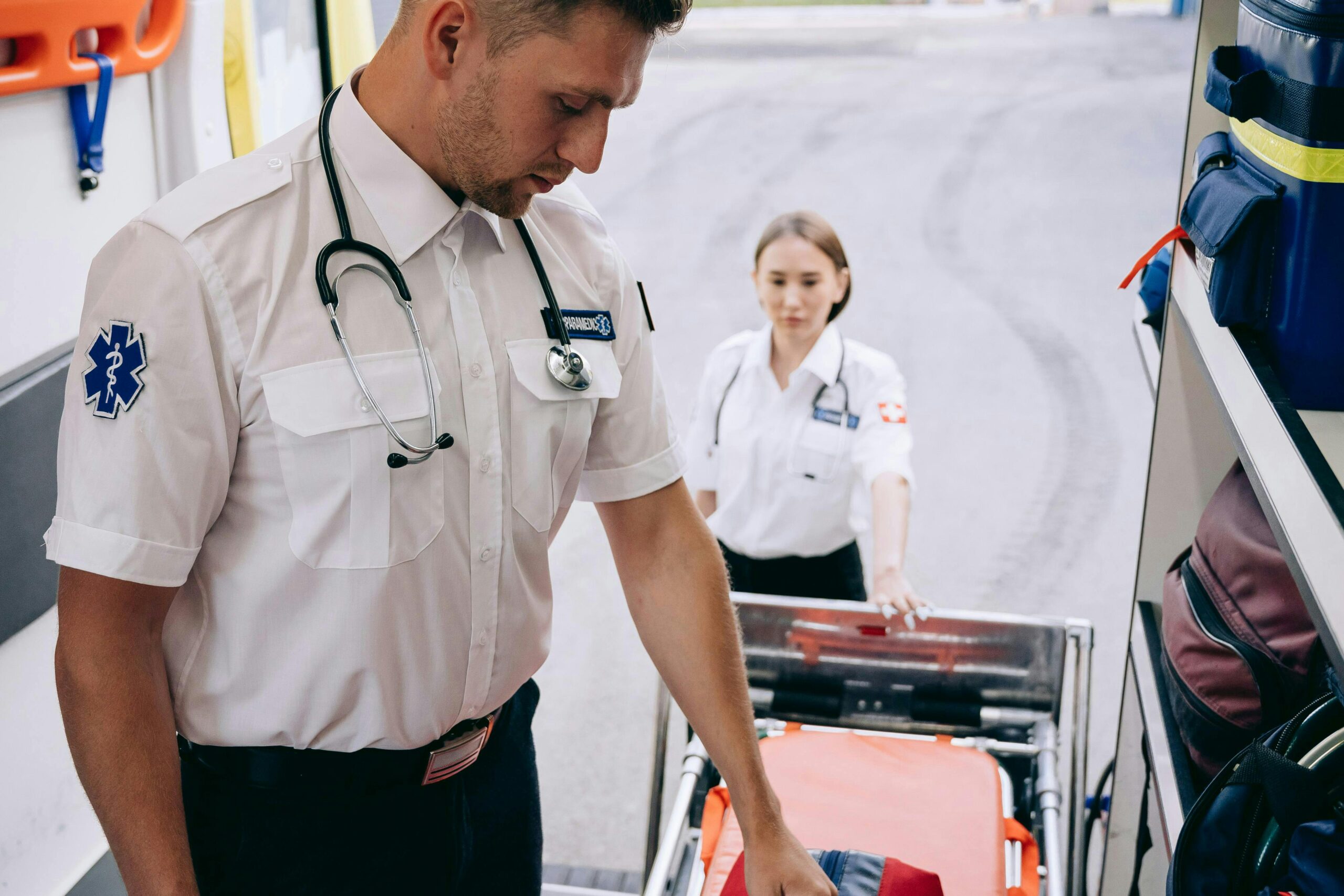 Paramedics readying a stretcher within an ambulance for emergency response.